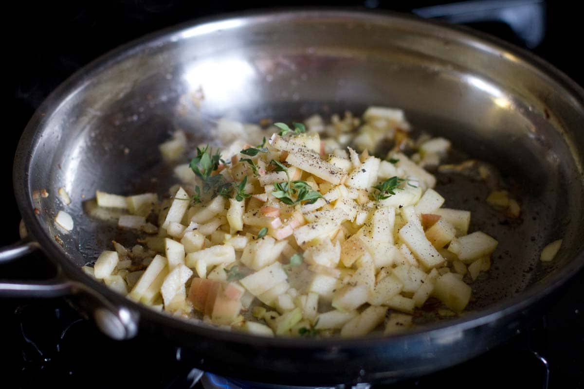 raw apples with herbs in a skillet