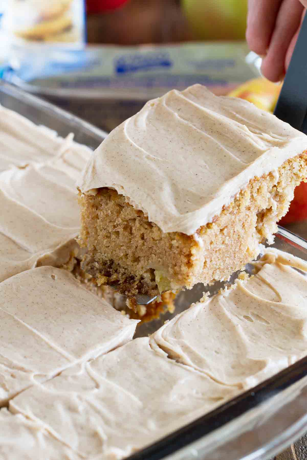 taking a piece of apple cinnamon cake from a pan