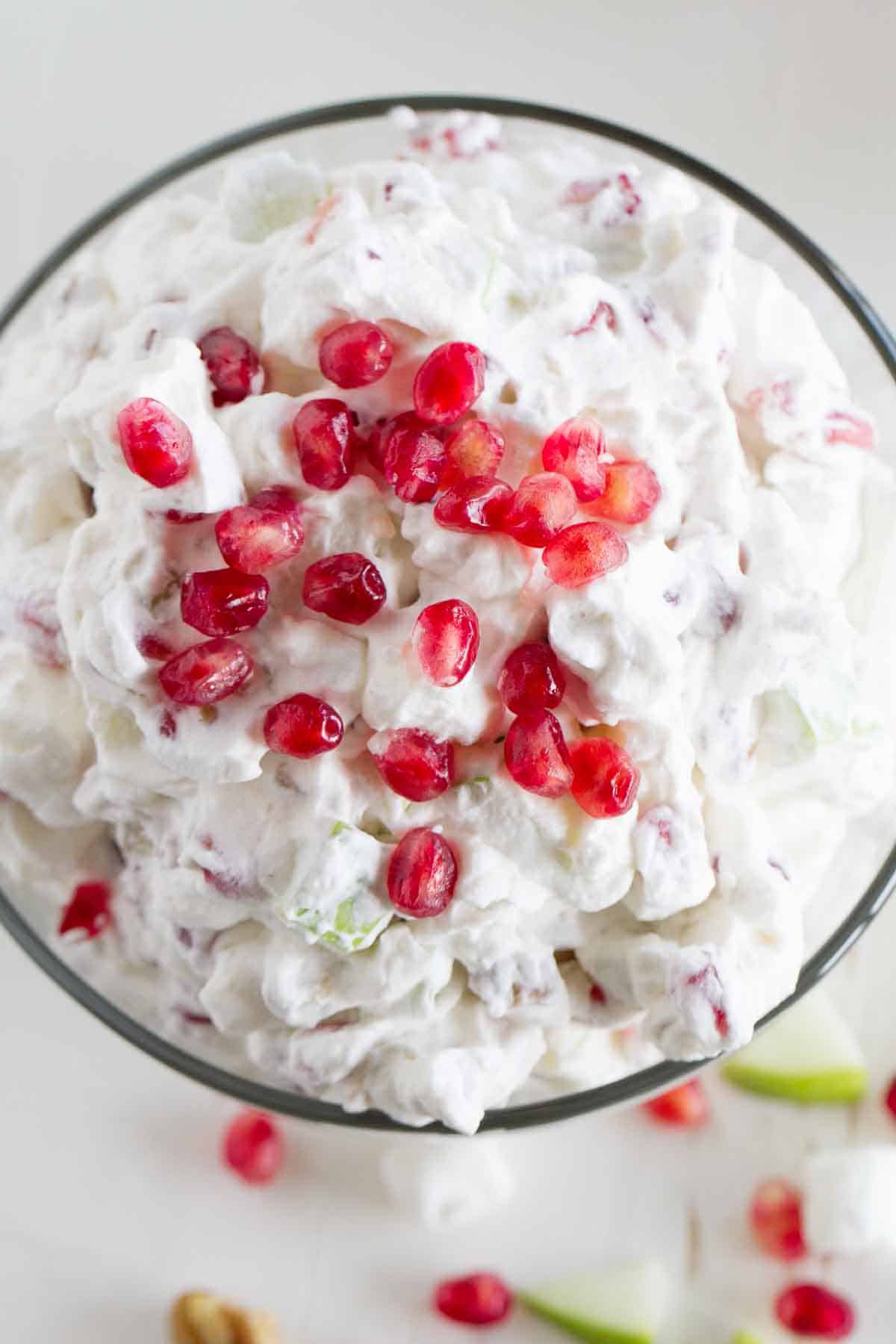 overhead view of apple pomegranate salad with pomegranate seeds sprinkled on top