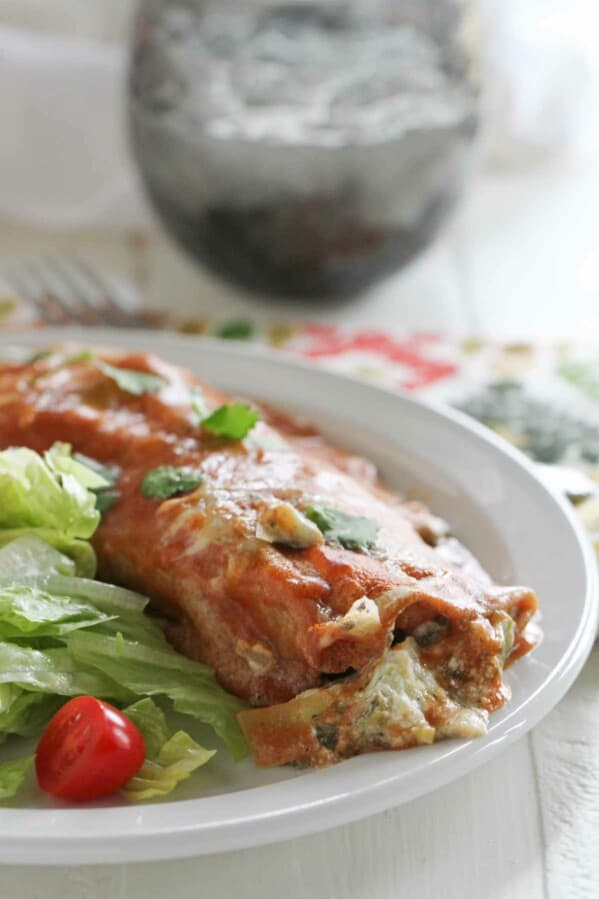 Single Artichoke and Spinach Enchilada on a plate with a salad