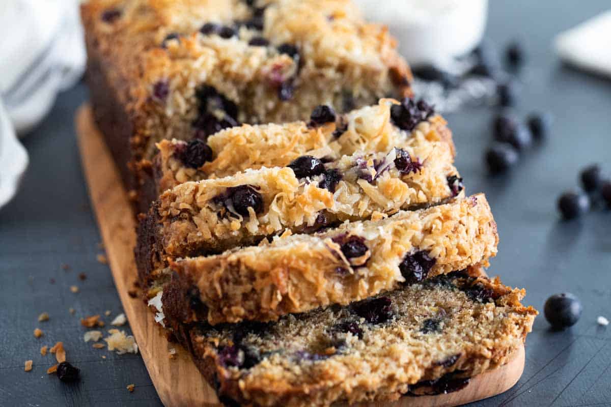 loaf of sliced blueberry banana bread on a cutting board.