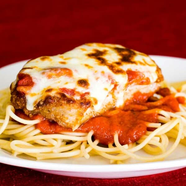 Boneless Pork Chops Parmigiana over spaghetti on a plate