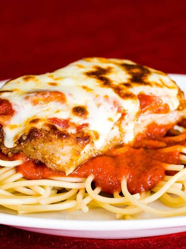 Boneless Pork Chops Parmigiana over spaghetti on a plate