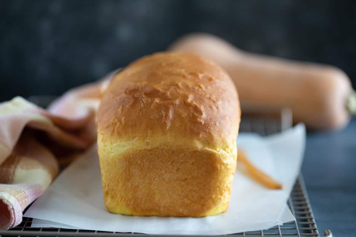 Baked loaf of butternut squash bread on a cooling rack.