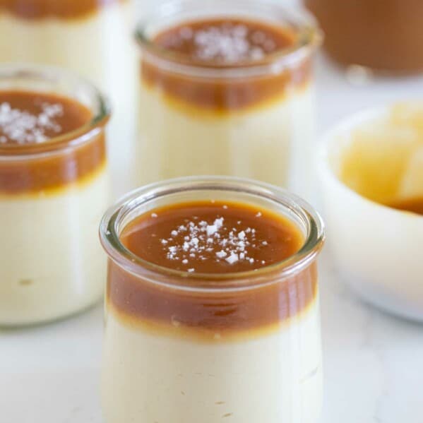 Glasses with butterscotch budino, topped with caramel and sea salt.