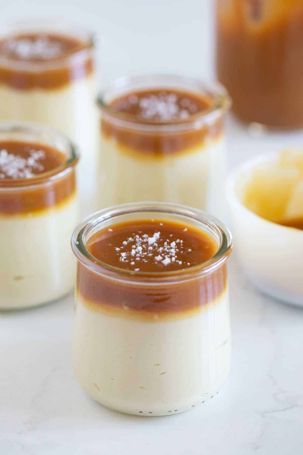 Glasses with butterscotch budino, topped with caramel and sea salt.