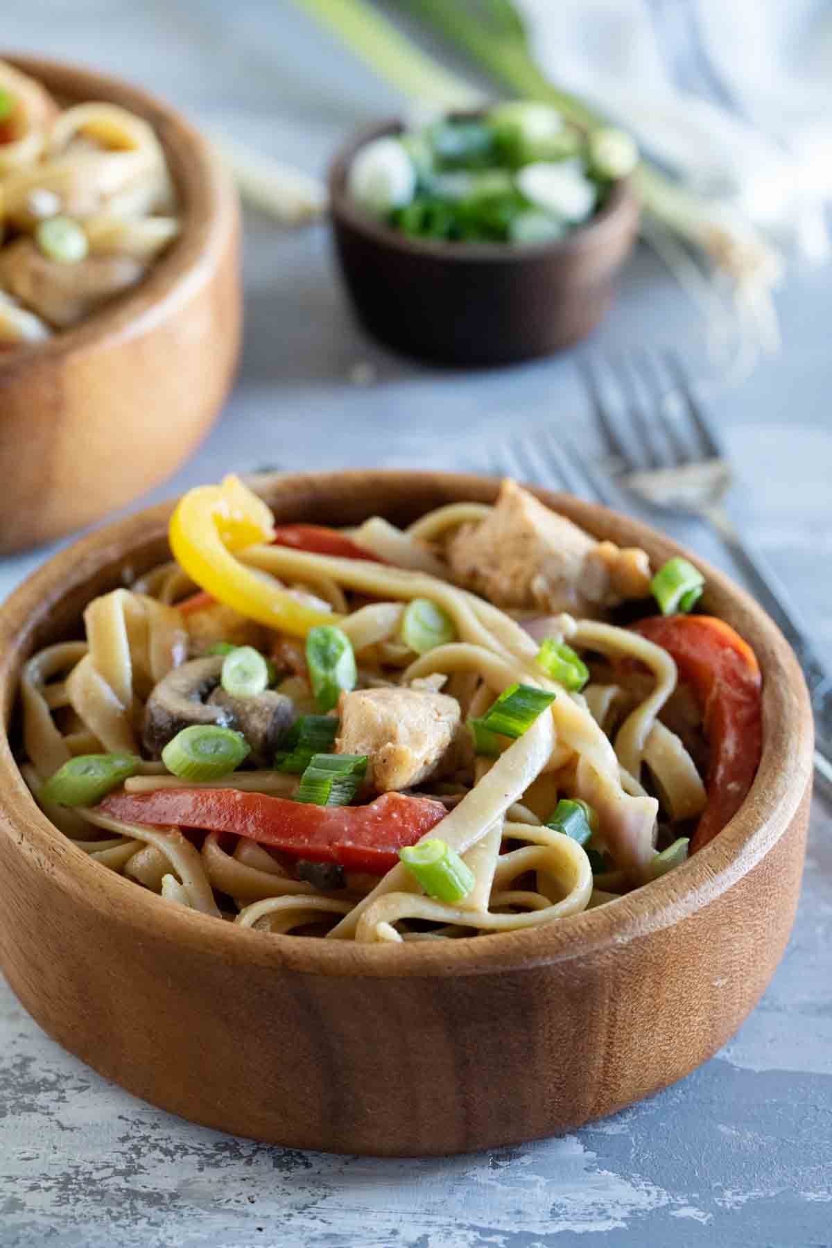 bowl with Cajun chicken pasta with ingredients in the background