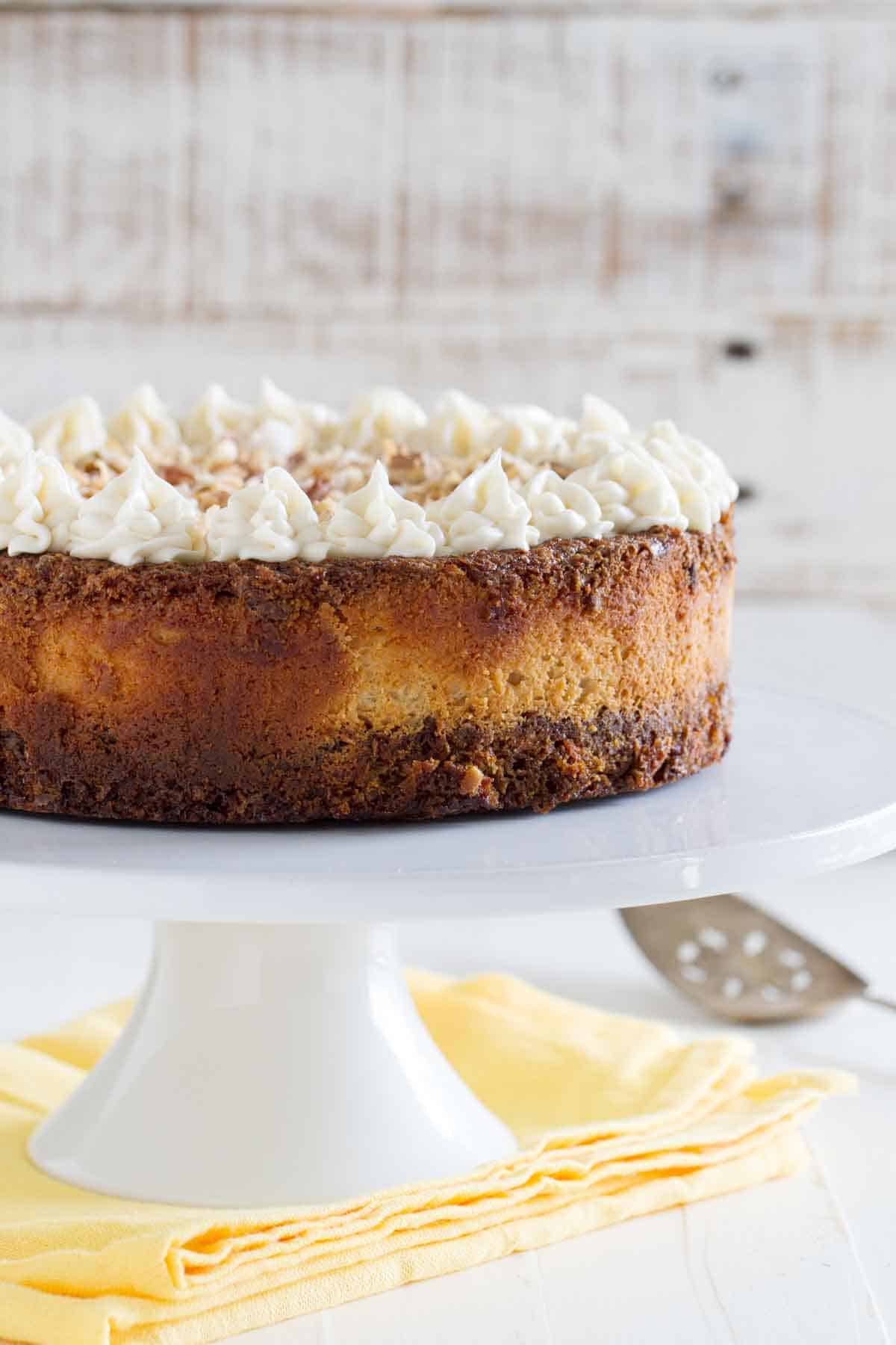 full carrot cake cheesecake on a cake stand