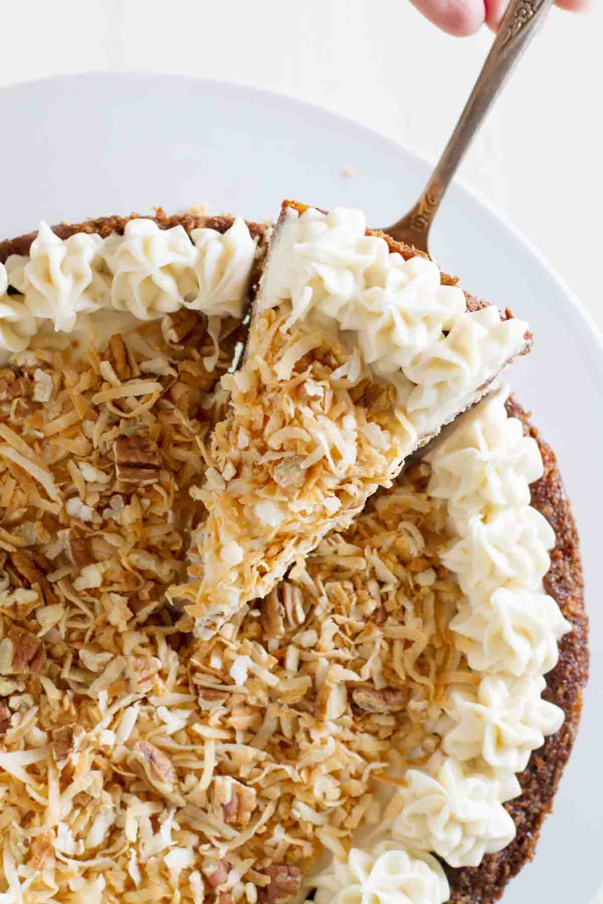 overhead view of a slice of carrot cake cheesecake being taken
