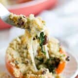 Stuffed tomato with a forkful of filling being scooped out.