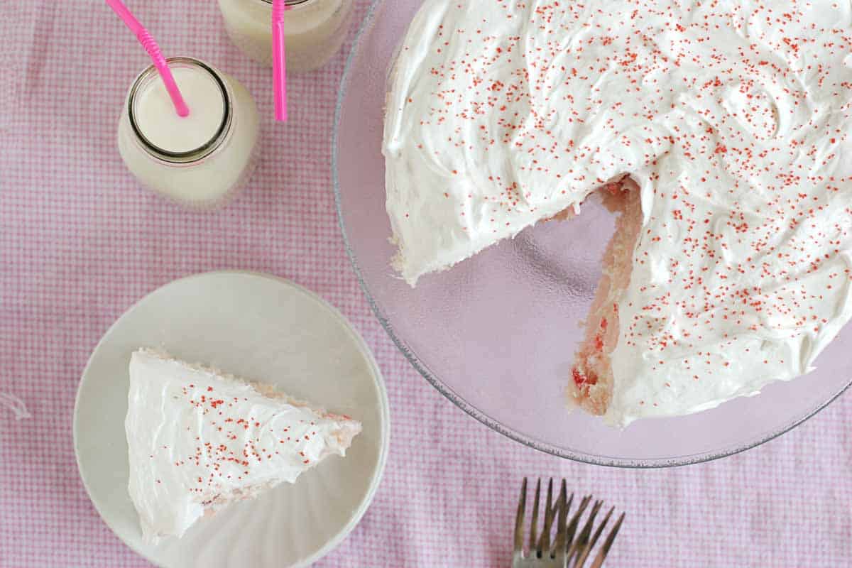 overhead photo of homemade cherry chip cake with a slice taken from it.