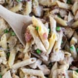 Overhead view of wooden serving spoon with Chicken Bacon Pasta.