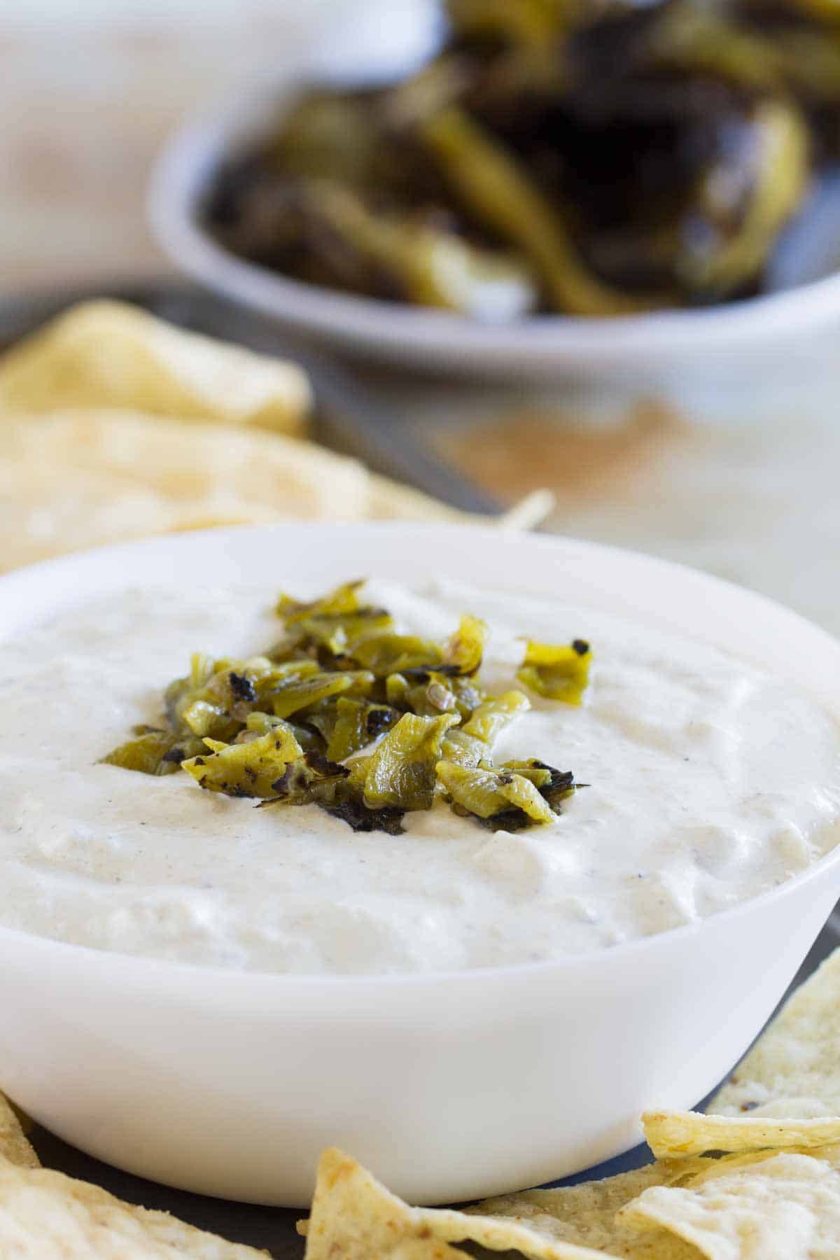 bowl filled with creamy hatch green chile dip with chopped chiles on top