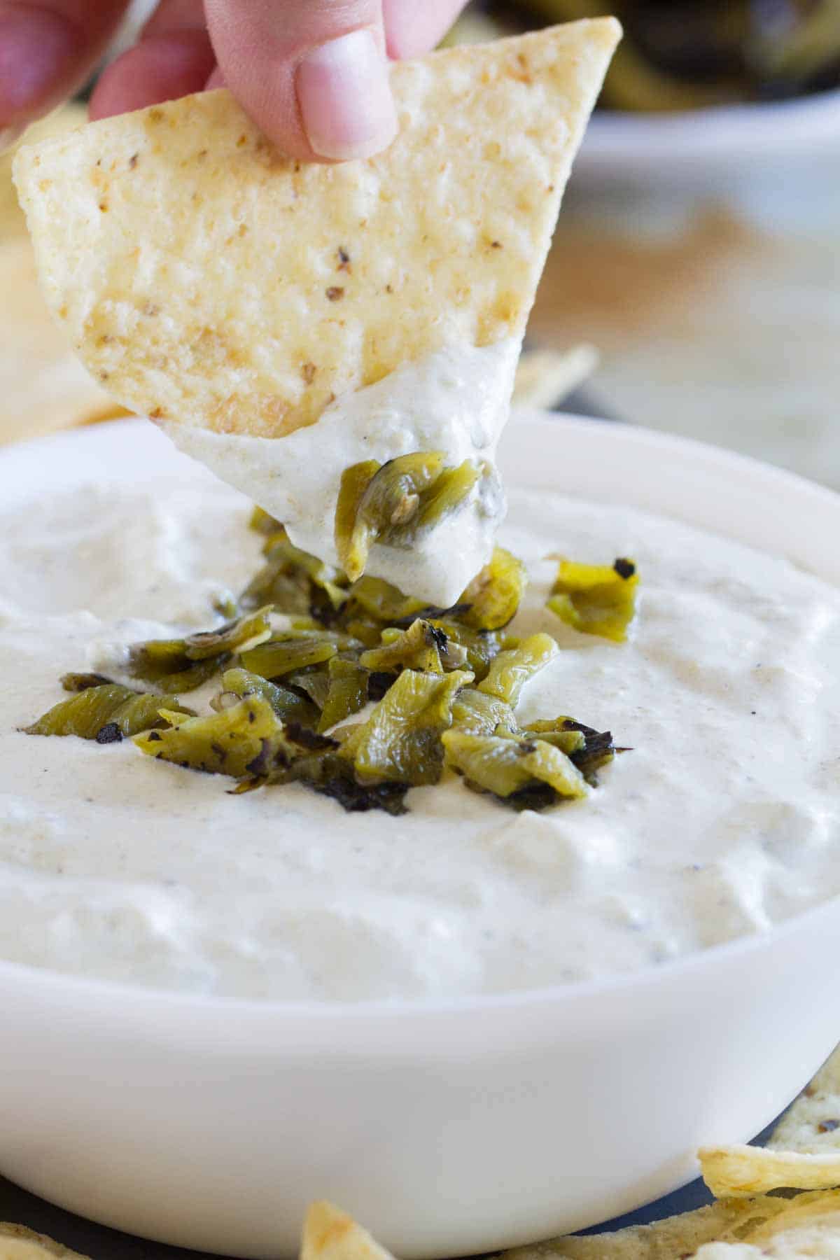 chip dipping into creamy hatch green chile dip