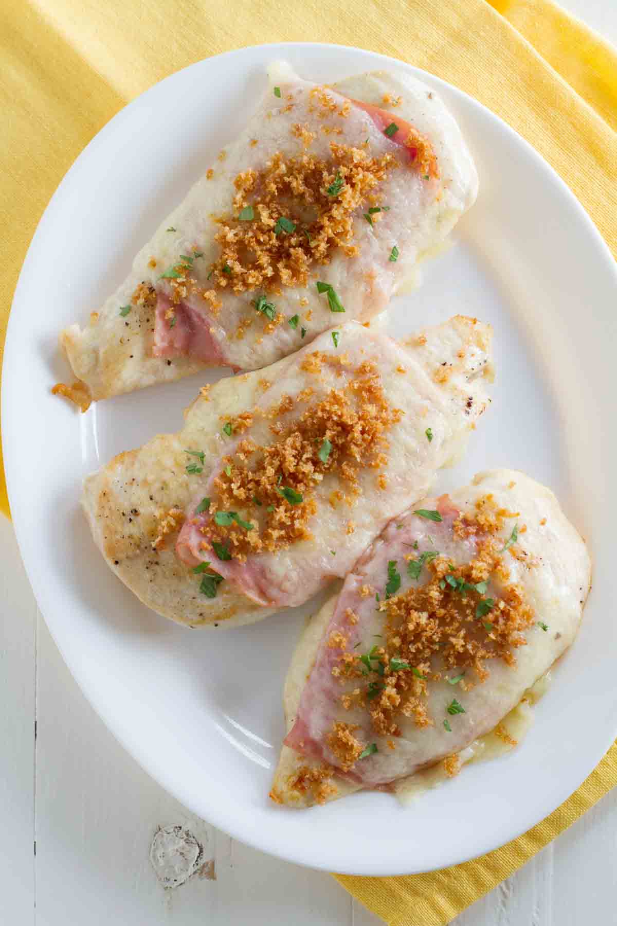 overhead view of chicken topped with ham, cheese, and breadcrumbs