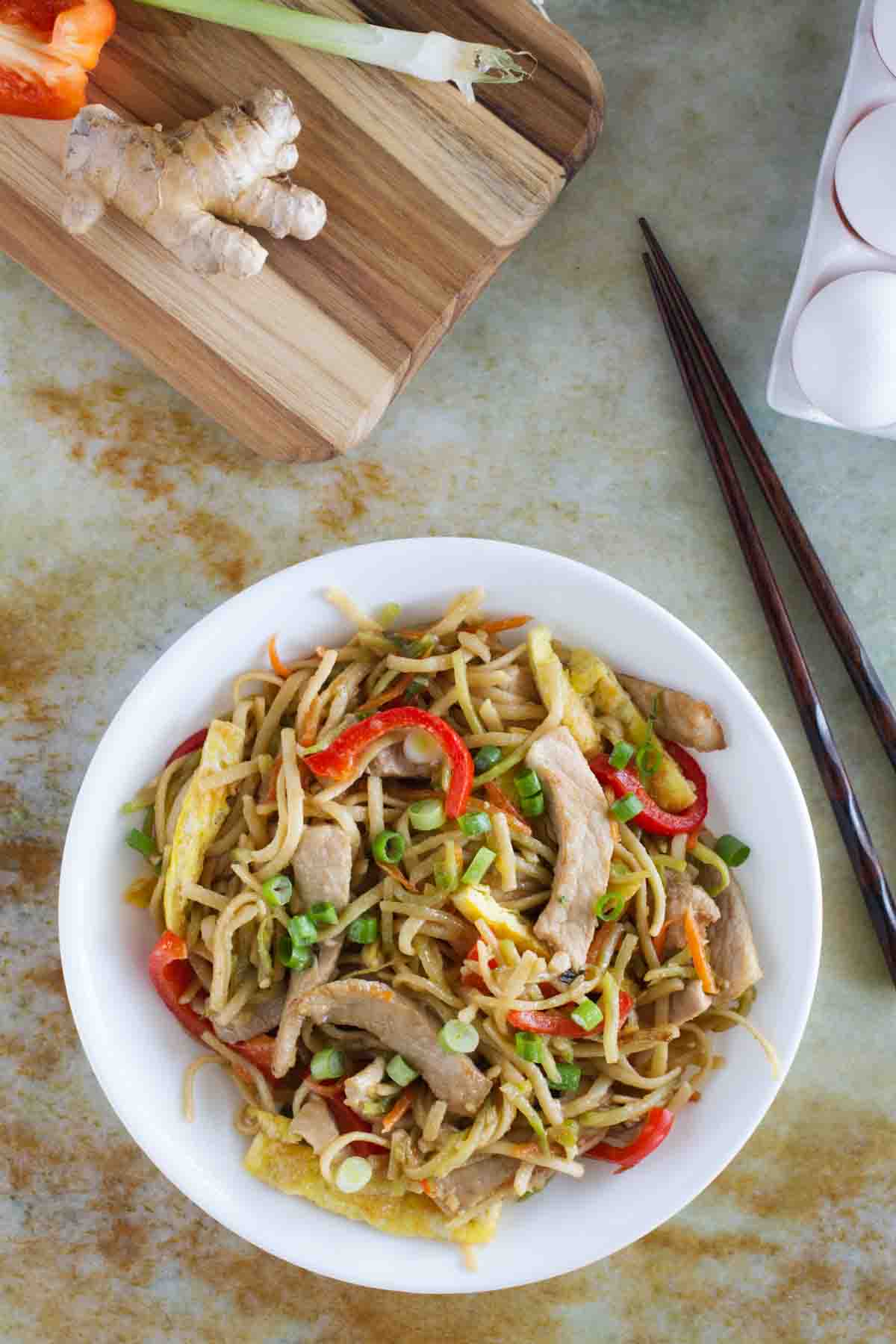 overhead view of bowl of egg and pork lo mein