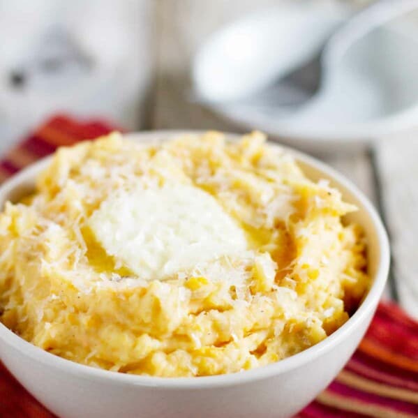 bowl filled with Golden Potato Mash with butter and cheese on top