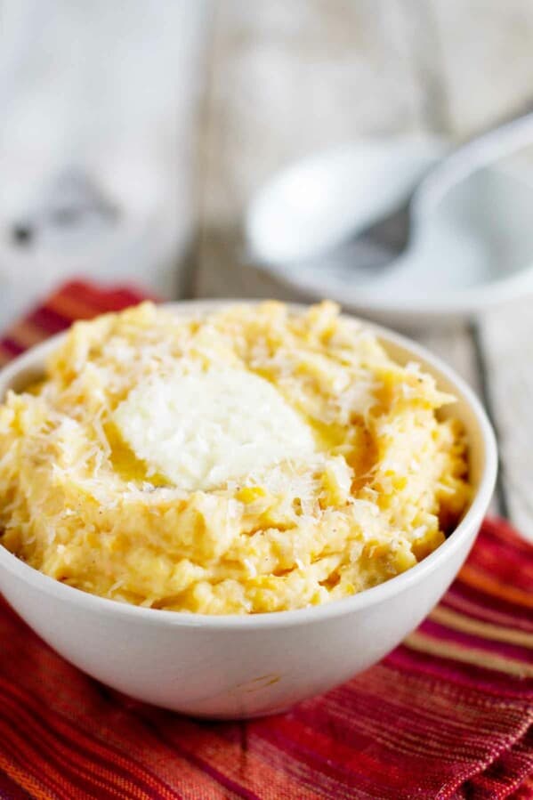 bowl filled with Golden Potato Mash with butter and cheese on top