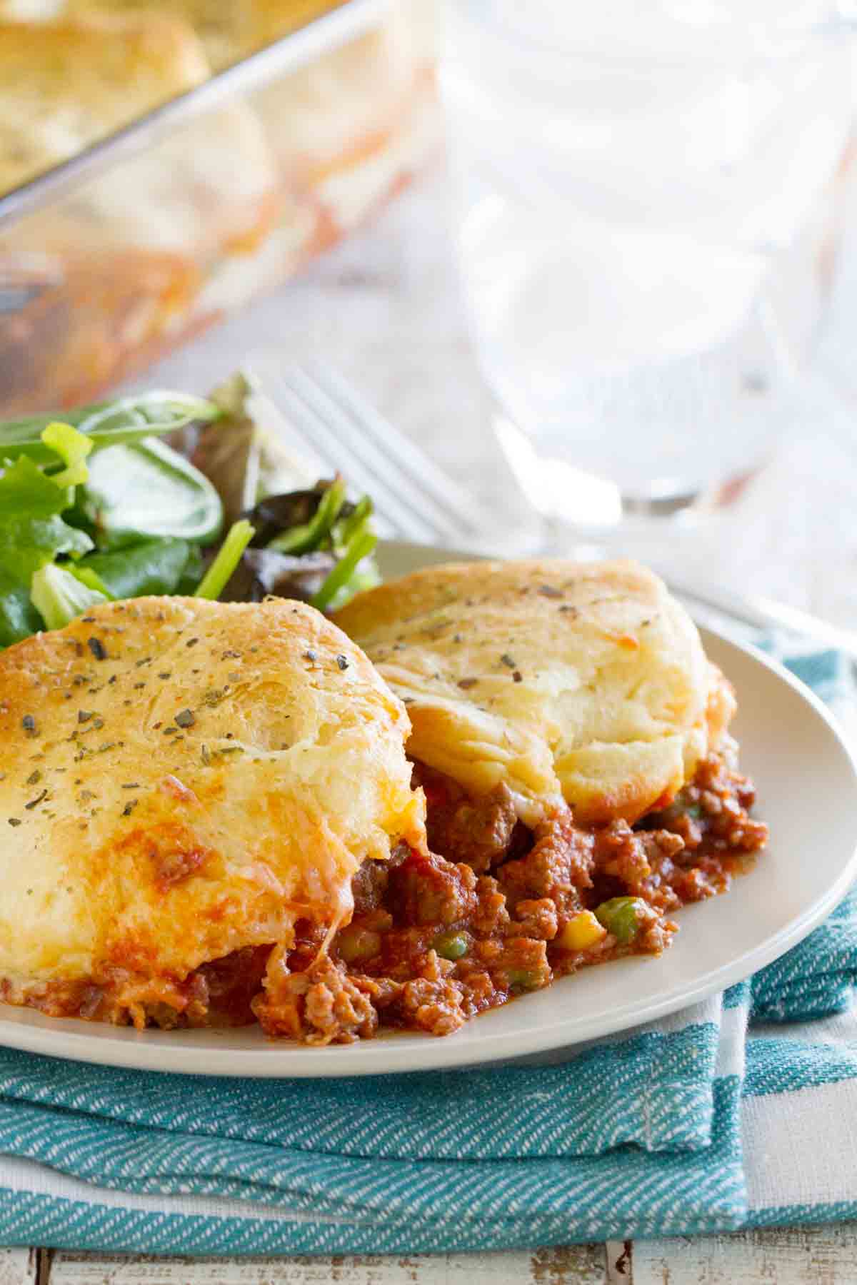 plate with a serving of Italian Ground Beef Casserole topped with biscuits