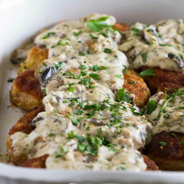 Italian pork chops in a baking dish topped with creamy mushroom gravy