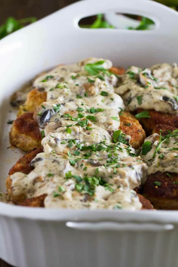 Italian pork chops in a baking dish topped with creamy mushroom gravy