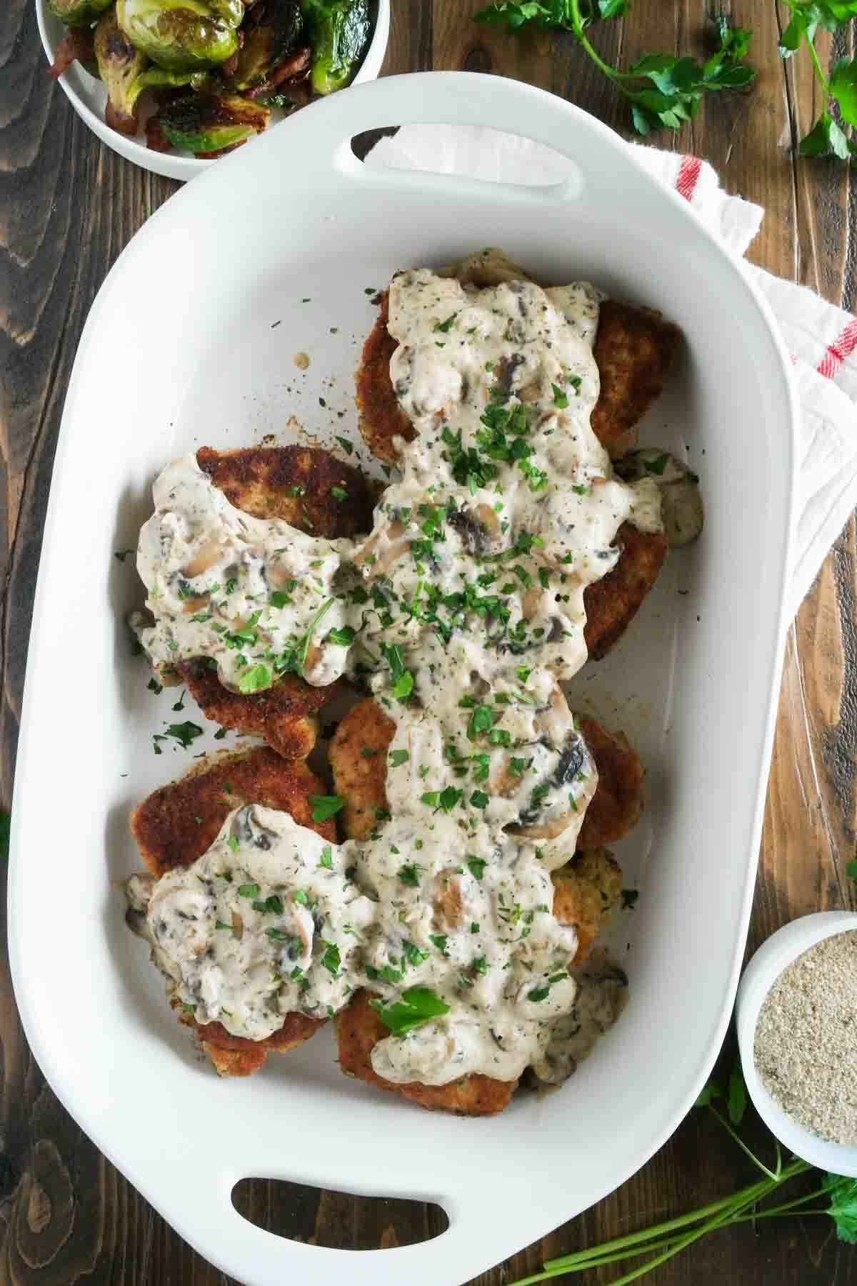 overhead view of pork chops in a baking dish topped with gravy