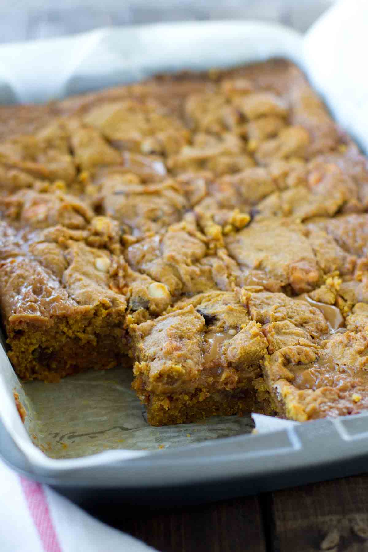 pan of Loaded Caramel Pumpkin Blondies with a few taken out.