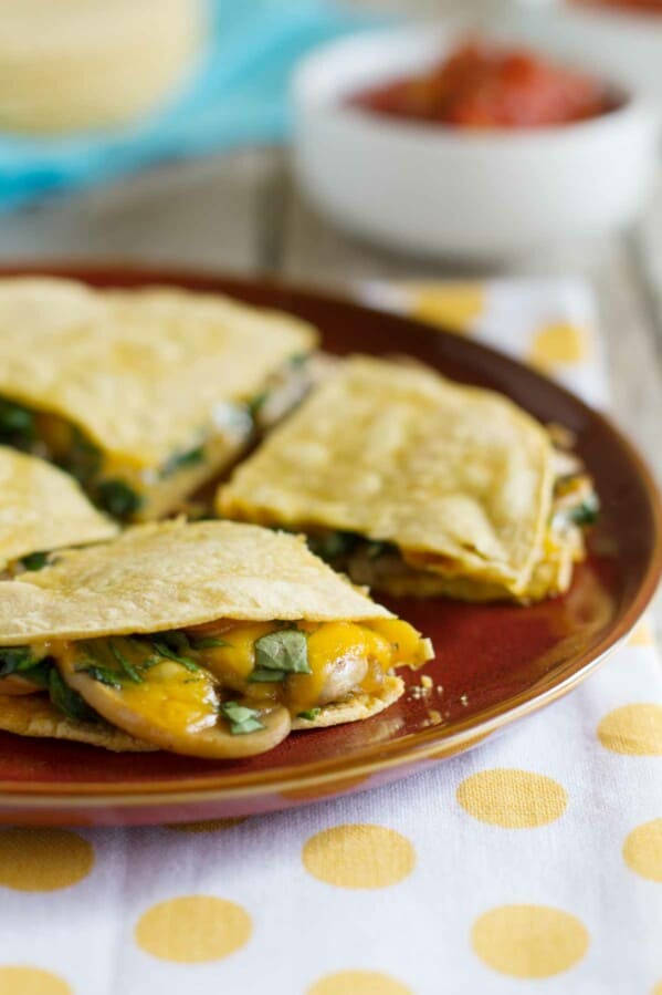 Mushroom Spinach Quesadillas on a plate showing cheese and mushrooms oozing out