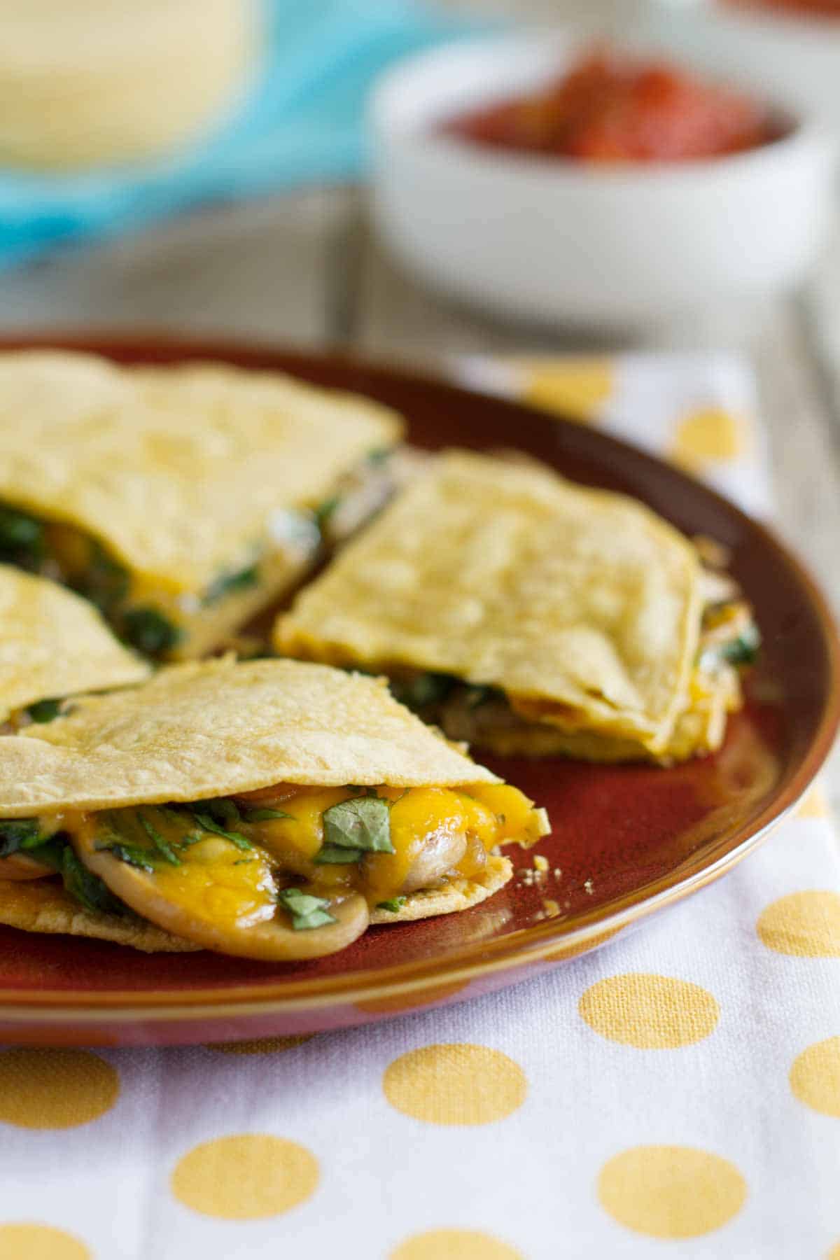 Mushroom Spinach Quesadillas on a plate showing cheese and mushrooms oozing out