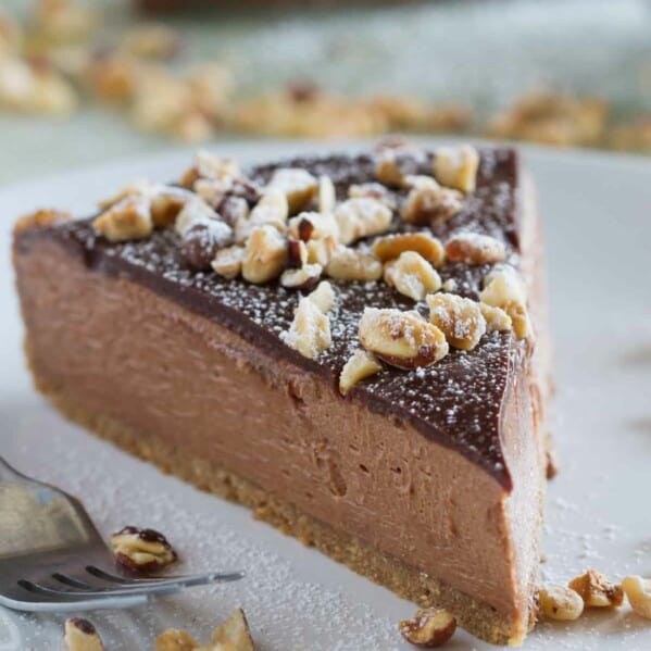 slice of no bake nutella cheesecake topped with hazelnuts