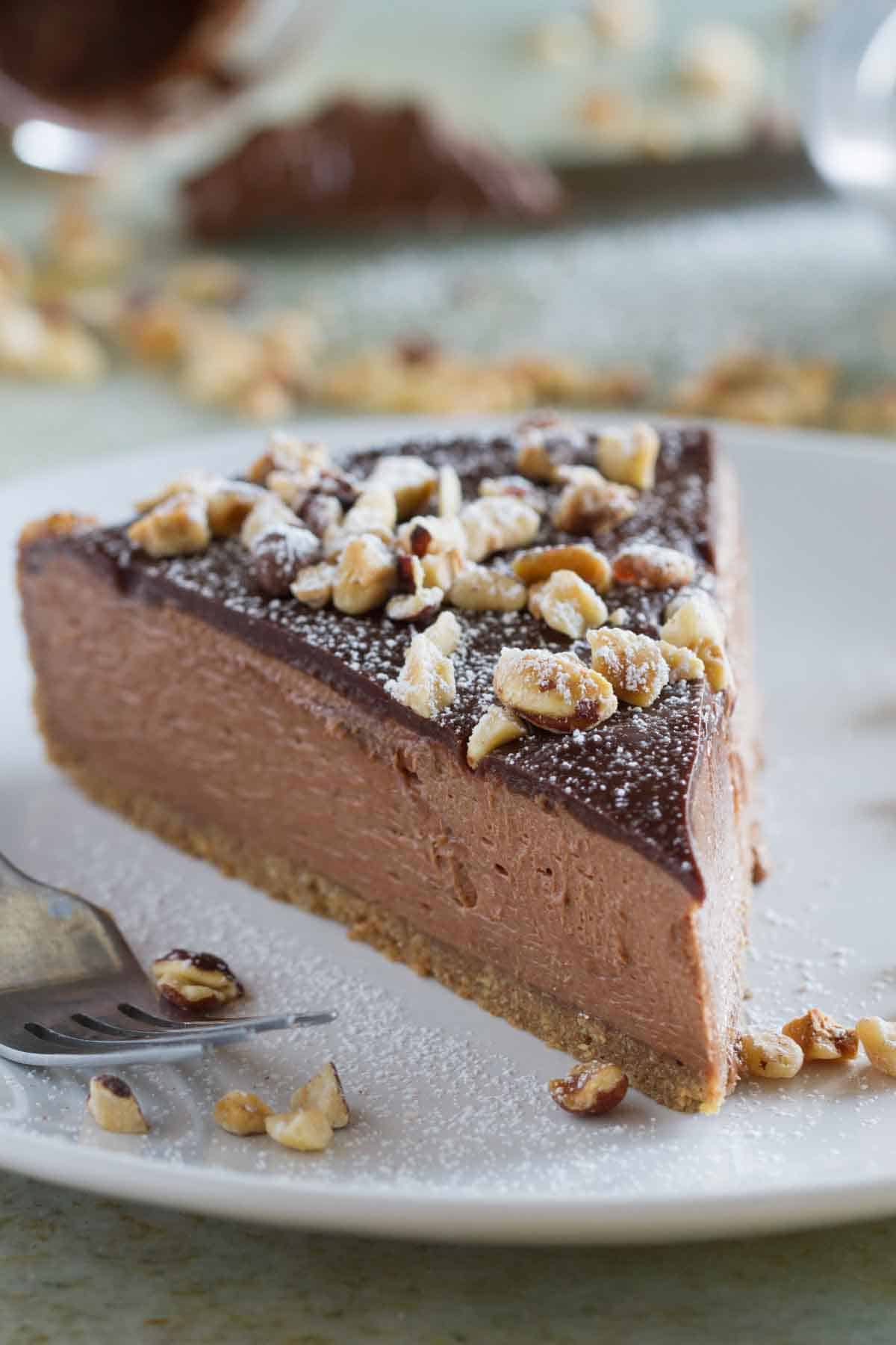 slice of no bake nutella cheesecake topped with hazelnuts