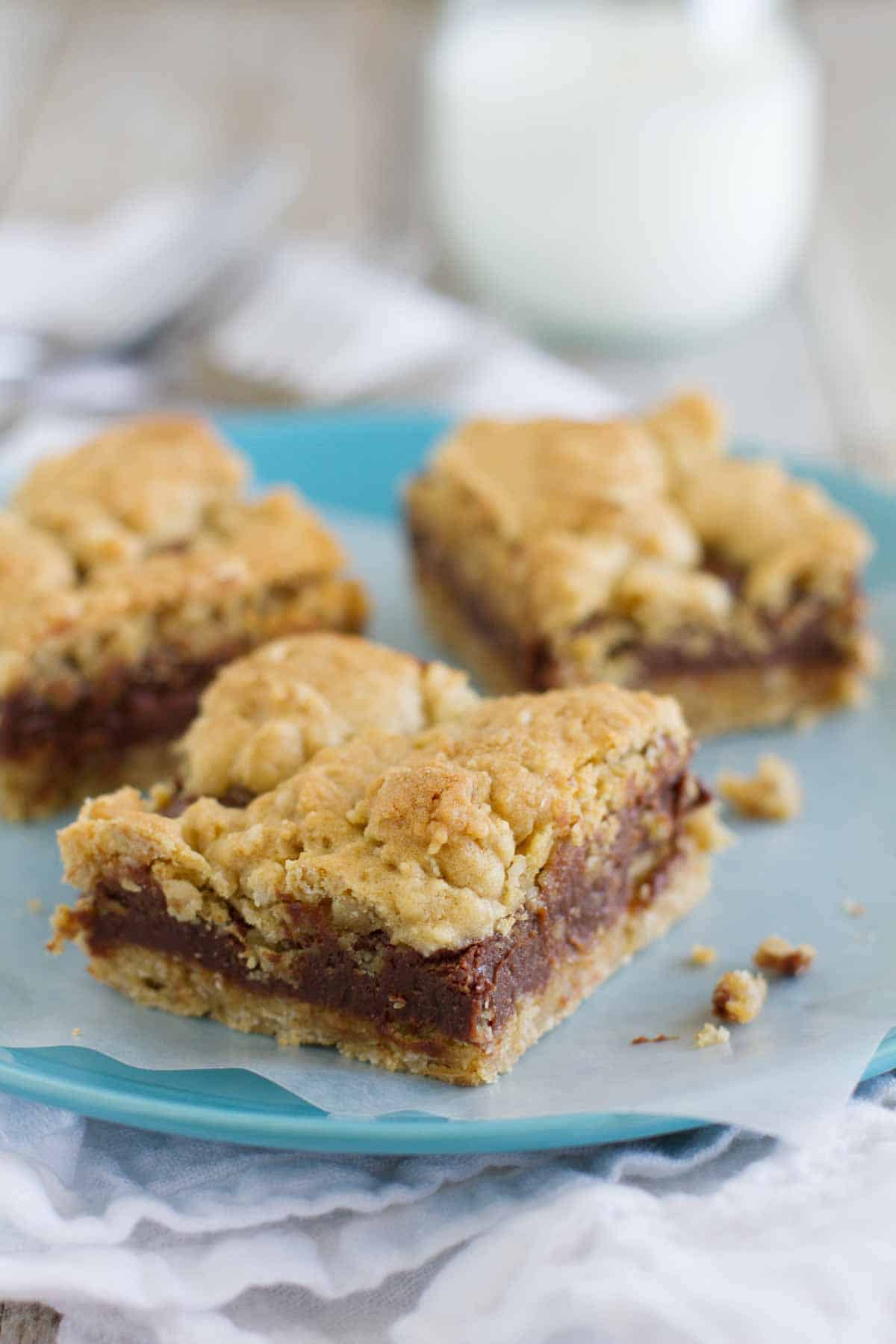 Three Oatmeal Fudge Bars on a plate with parchment under them.