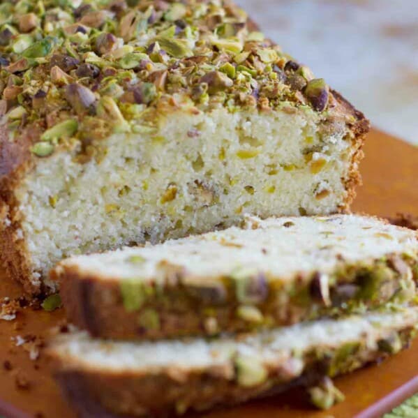 loaf of pistachio lemon pound cake with 2 slices
