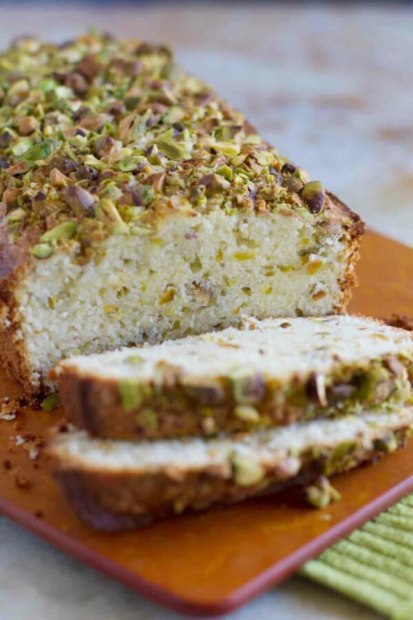 loaf of pistachio lemon pound cake with 2 slices
