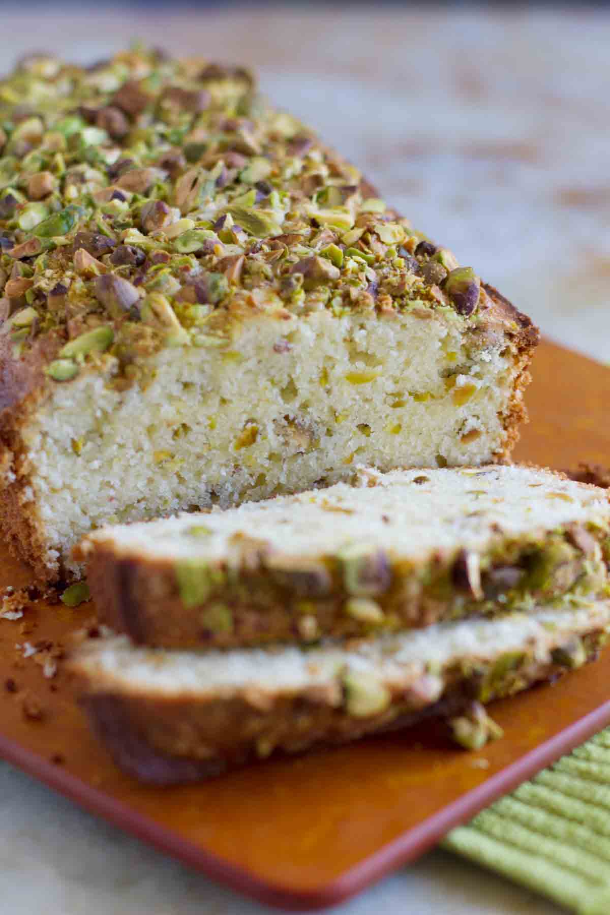 loaf of pistachio lemon pound cake with 2 slices