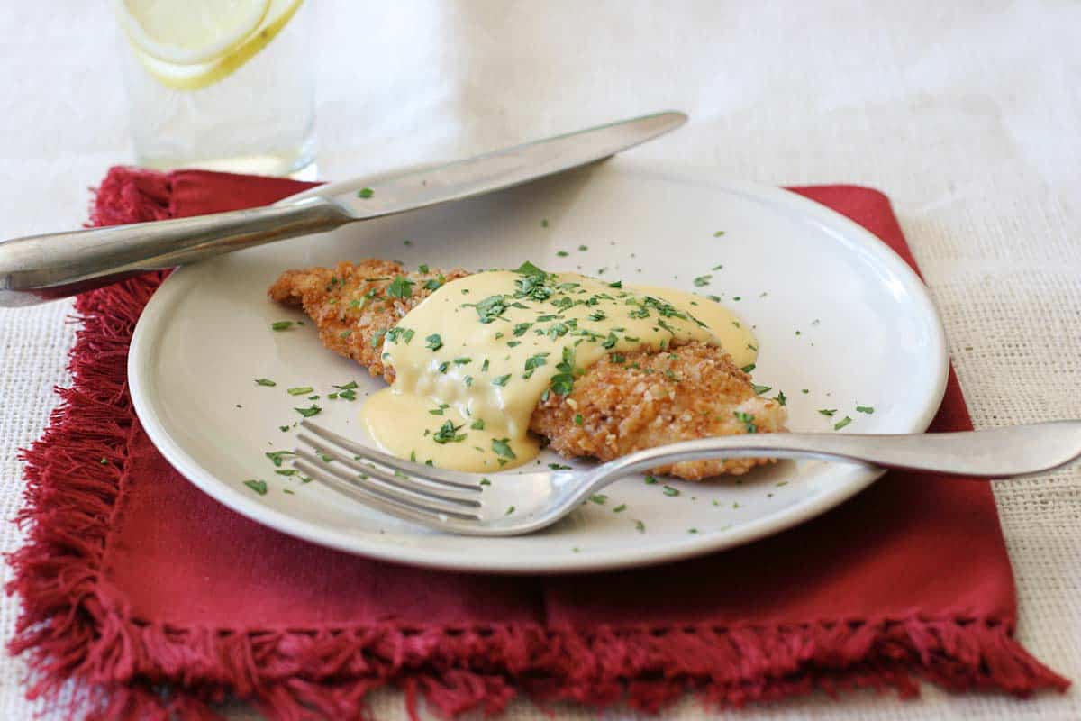 serving of pretzel crusted chicken on a plate with a fork and knife