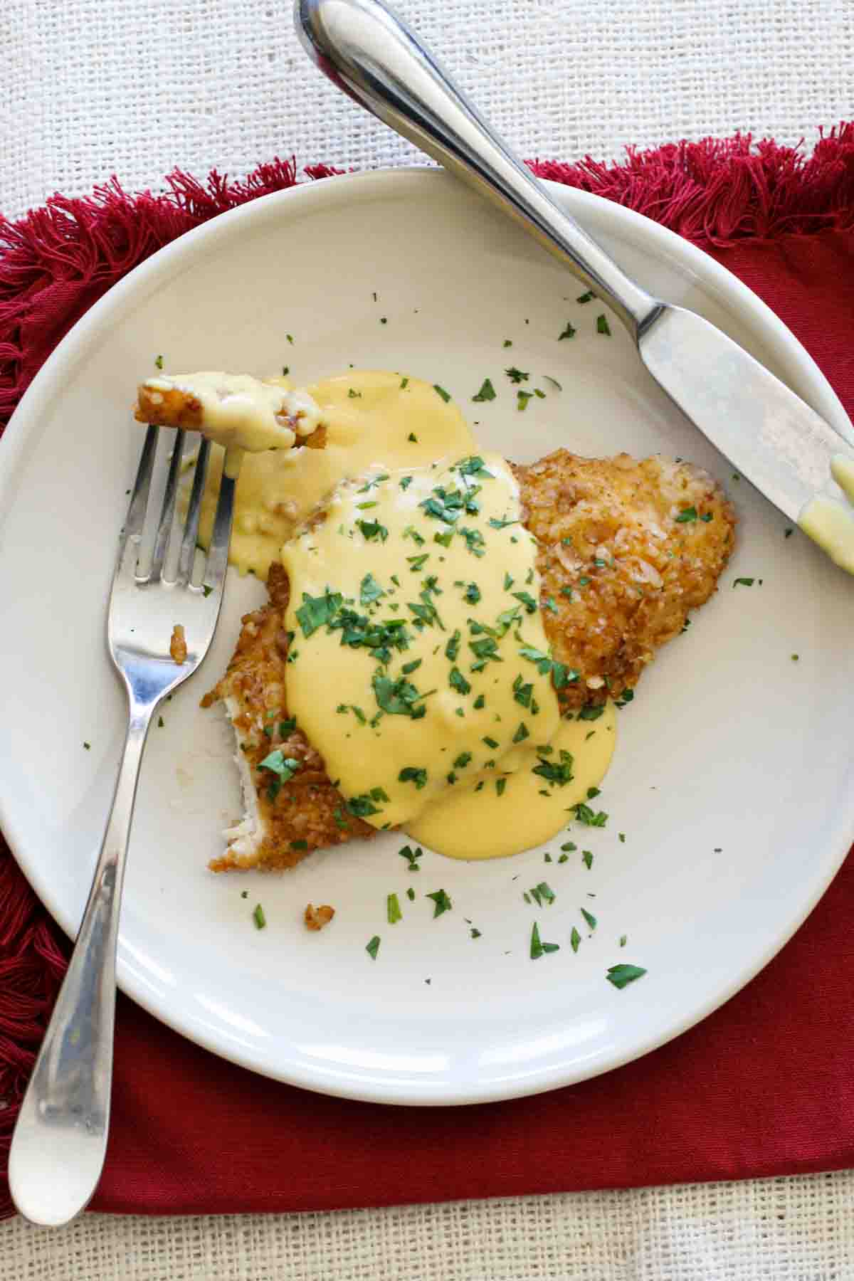 overhead view of piece of pretzel crusted chicken covered in mustard-cheddar sauce.
