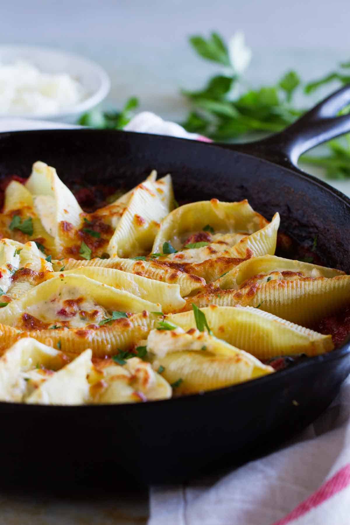 Dinner is served! These Stuffed Pasta Shells with Easy Bolognese Sauce look like they take a lot of time and effort, but the recipe comes together quickly enough for a weeknight dinner! Stuffed Pasta Shells with Easy Bolognese Sauce in a cast iron skillet