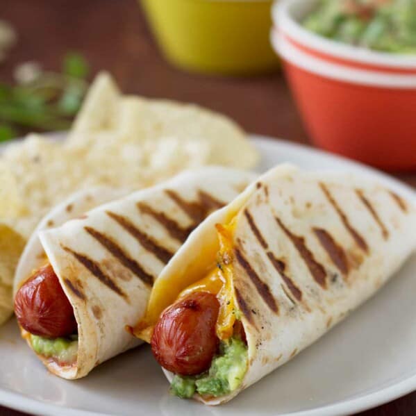 Two Taco Dogs on a plate - hot dogs wrapped in a tortilla and grilled