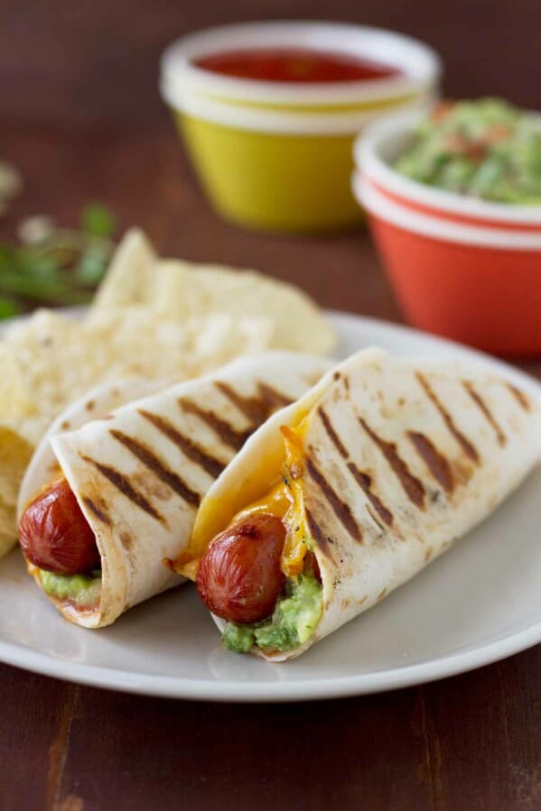 Two Taco Dogs on a plate - hot dogs wrapped in a tortilla and grilled