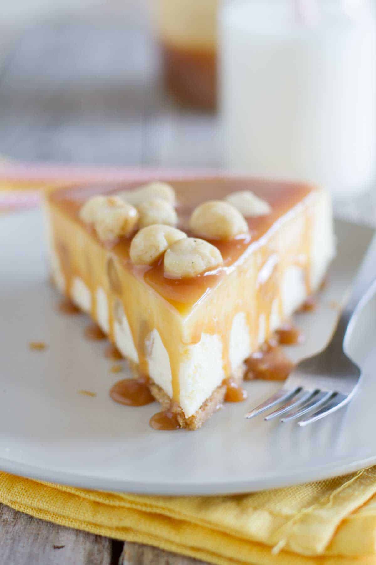 close up of slice of white chocolate cheesecake with caramel dripping
