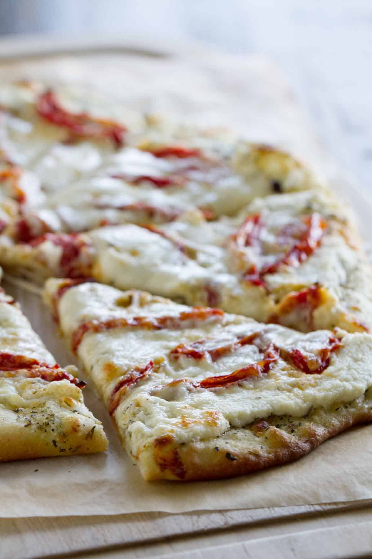 slice of white pizza topped with roasted tomatoes