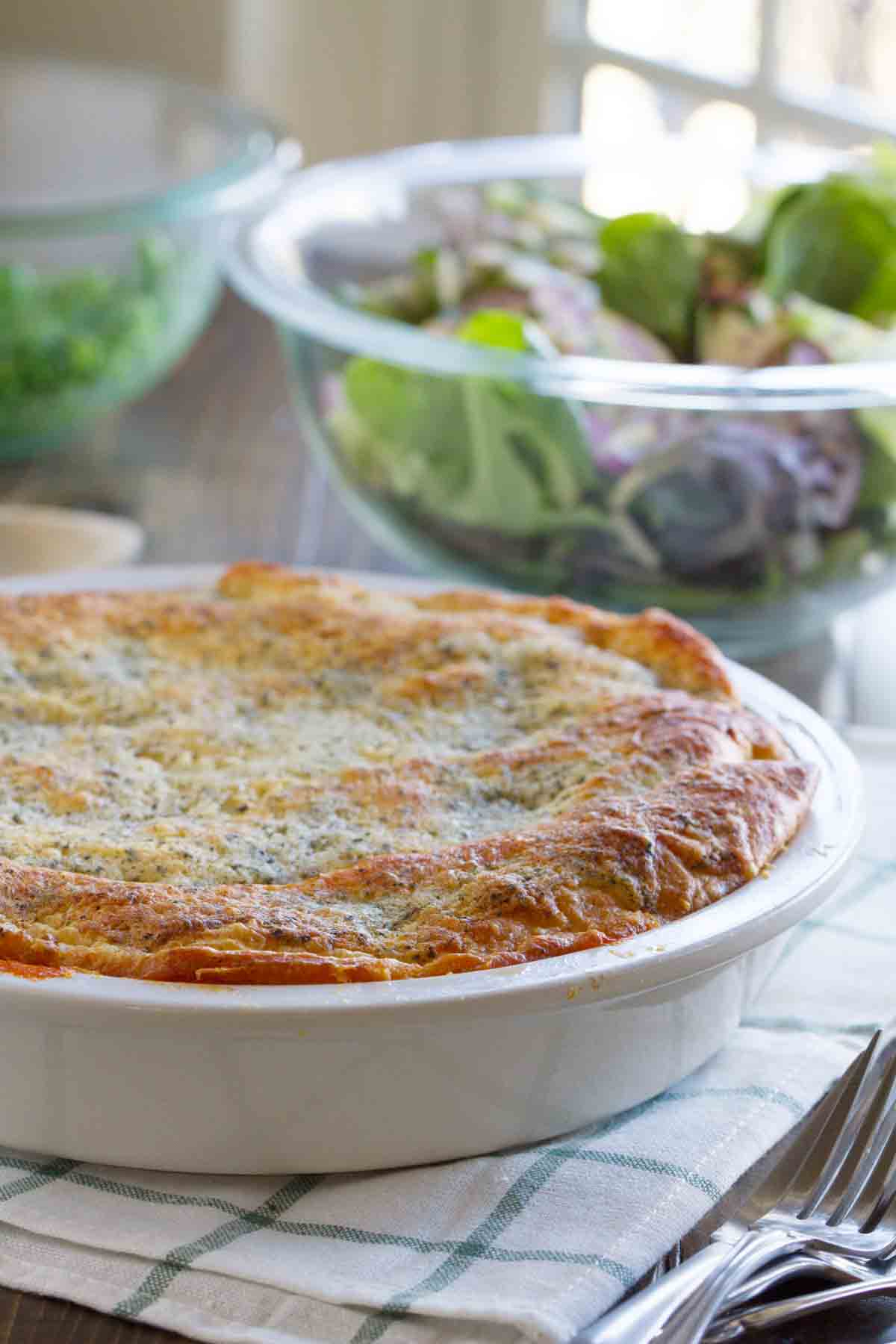 Ground beef is combined with pasta sauce, then topped with lots of cheese and a crescent roll crust in this Zesty Italian Crescent Casserole that the whole family will love. full Zesty Italian Crescent Casserole with a salad behind