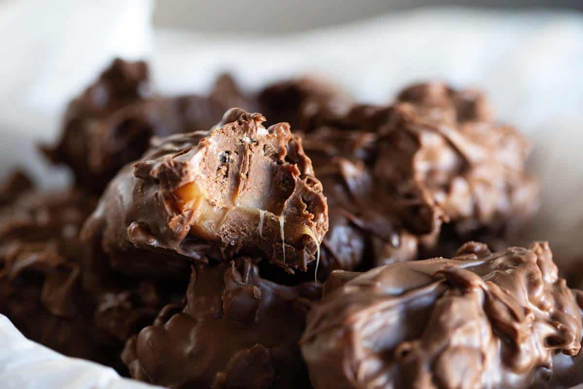 bowl of 100 grand candy bars with a bite taken from the one on top.