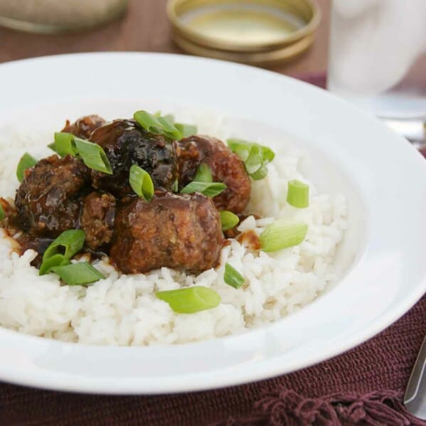 Asian Meatballs on top of rice with green onions.