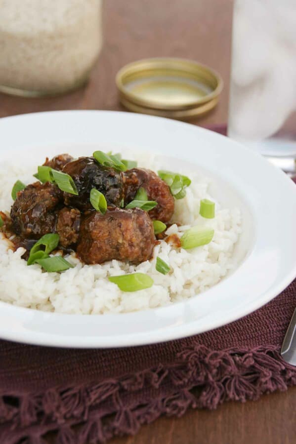 Asian Meatballs on top of rice with green onions.