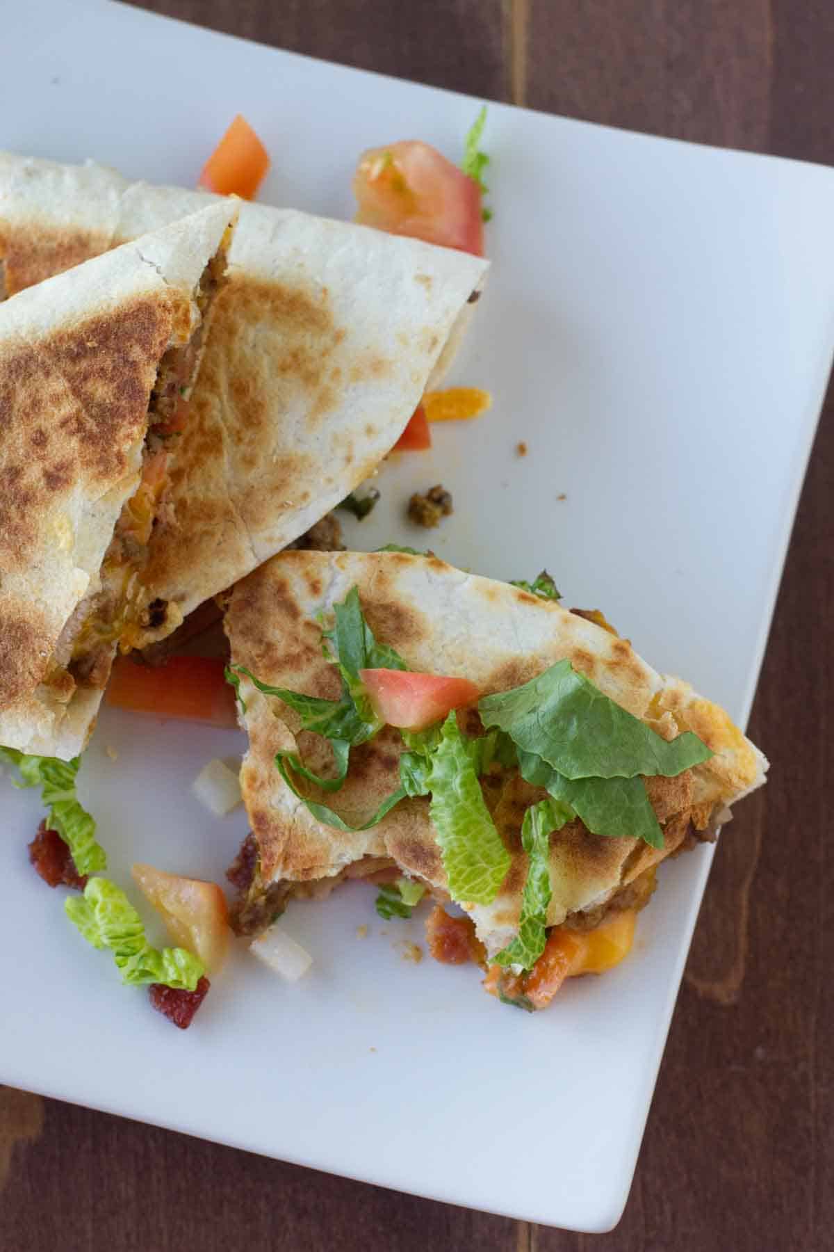 overhead view of Bacon Cheeseburger Quesadillas with a bite taken from one