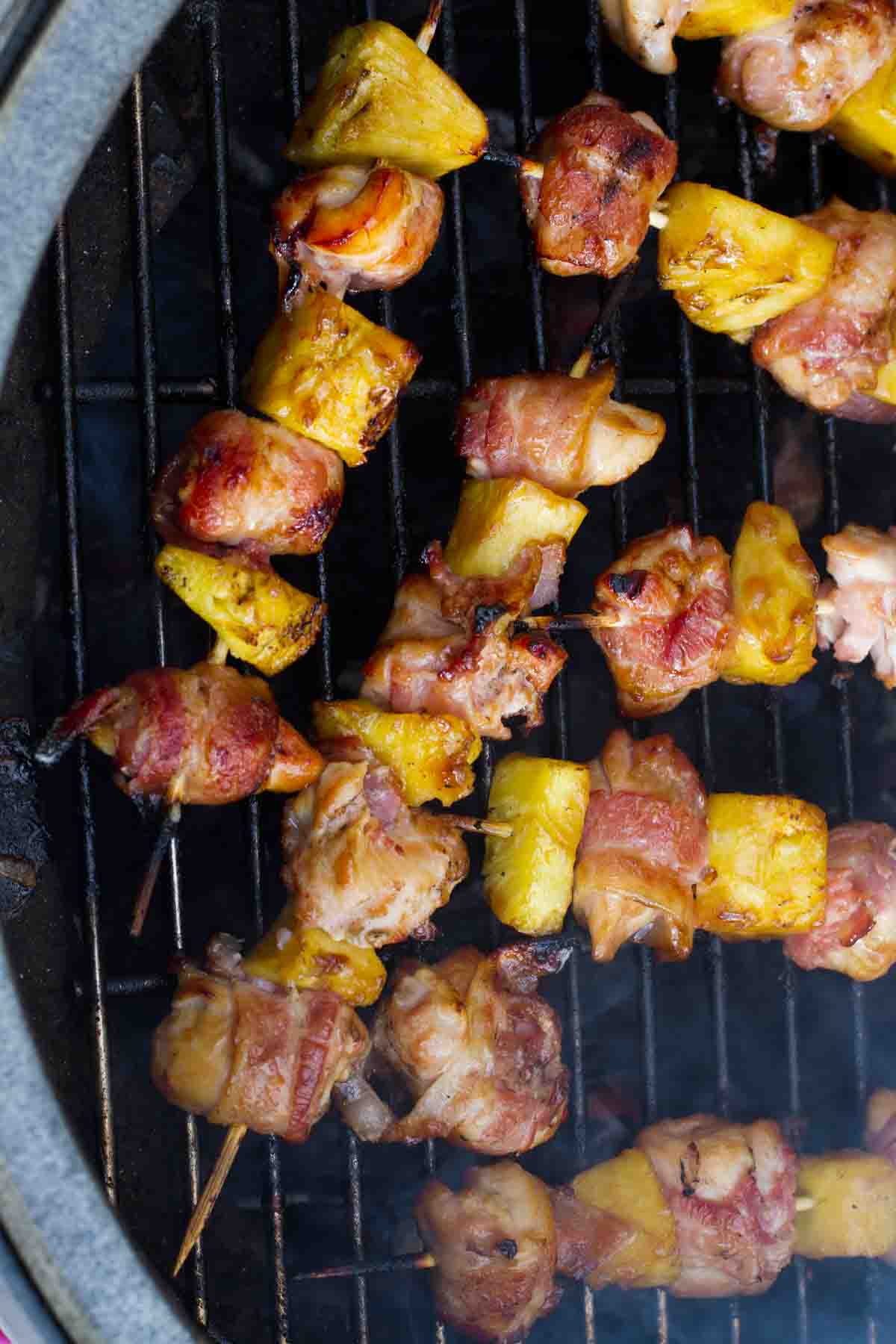 Bacon Wrapped Teriyaki Chicken Skewers cooking on a grill