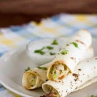 3 Baked Chicken Bacon Ranch Taquitos on a plate with dipping sauce.