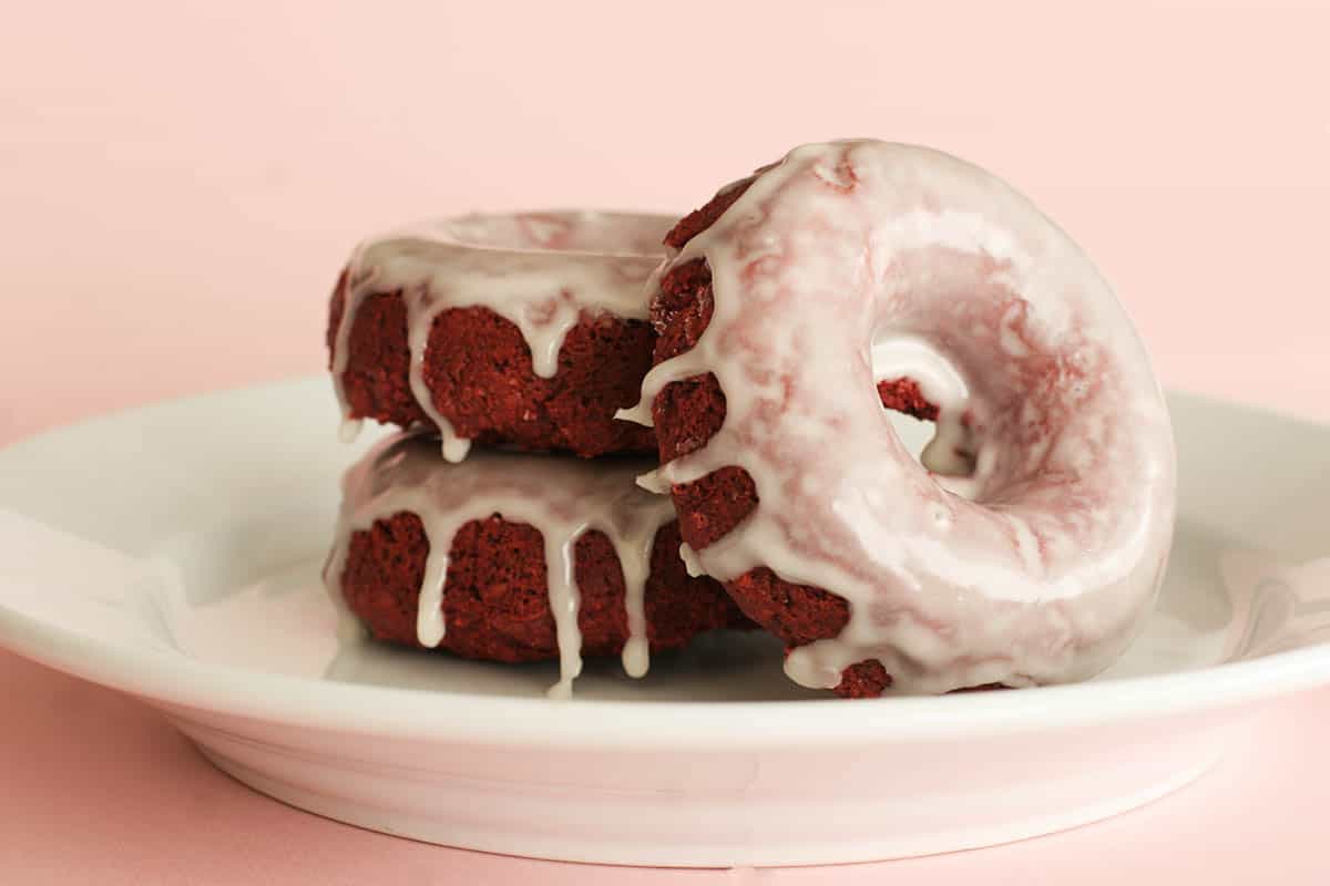 Baked Red Velvet Donuts - Red velvet meets baked donuts in this striking breakfast treat. three Baked Red Velvet Donuts on a plate